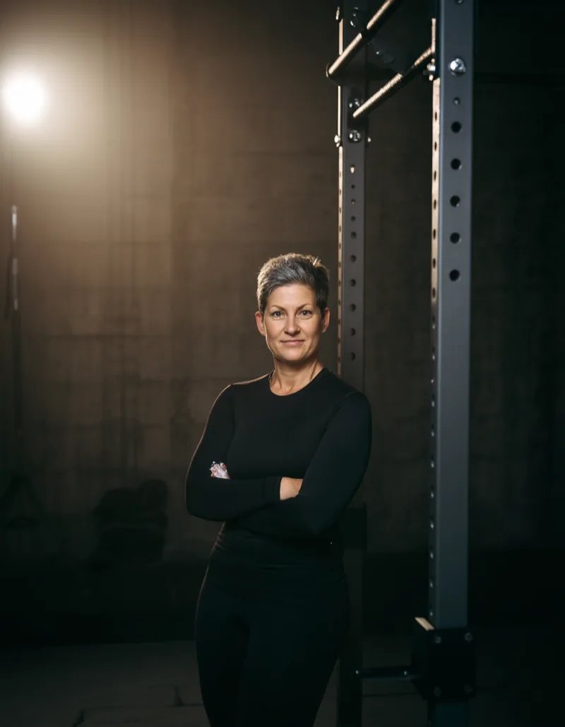 Portrait of Ruth Kalkbrenner, head coach at Eisenlager, in the hall by a loaded rack